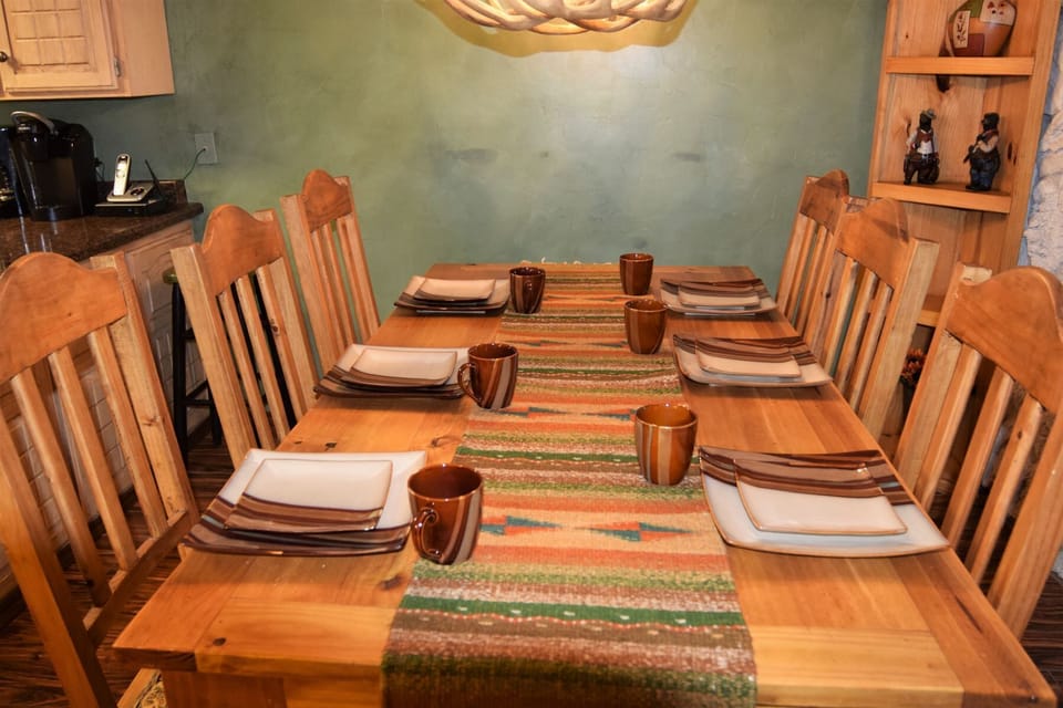 Gather around this welcoming table set for eight, where your group can share meals and stories in a warm, southwestern-styled dining space with handcrafted touches.