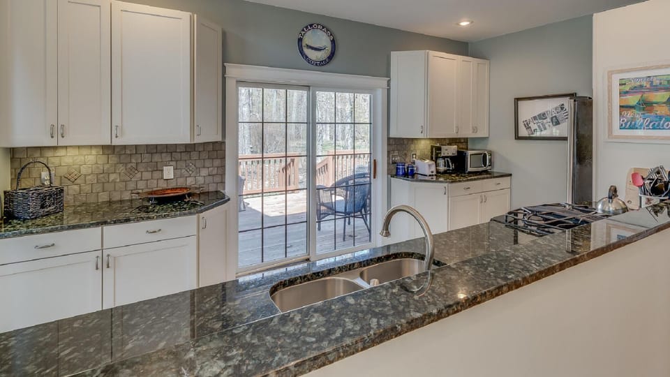 Modern, bright kitchen with granite countertops and garden views