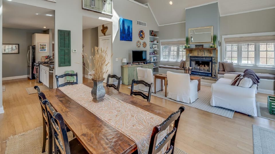 Spacious open-concept living and dining area with cozy fireplace