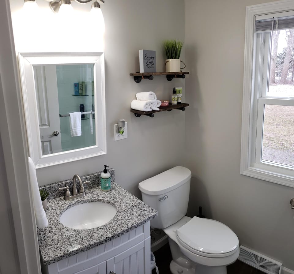 Our updated bathroom features a granite countertop and plenty of lighting.
