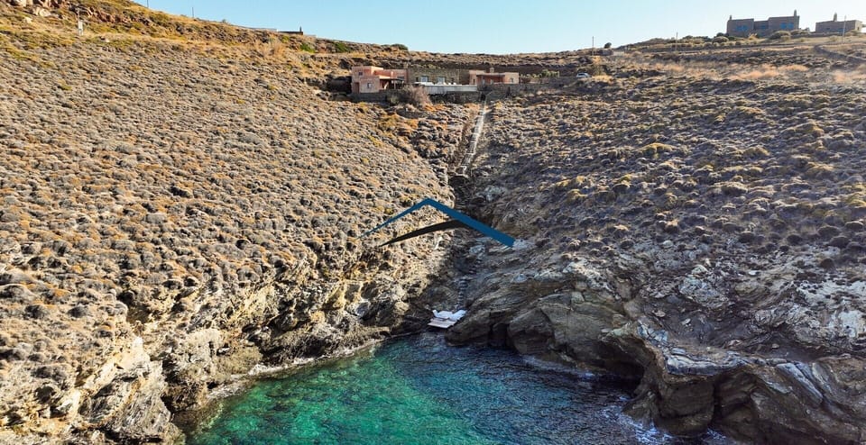 The wooden platform near the sea and the stairs leading up to the villa