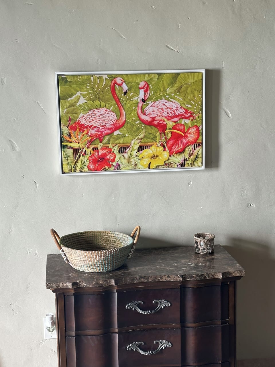 Marble topped dresser for storage with nice artwork above.