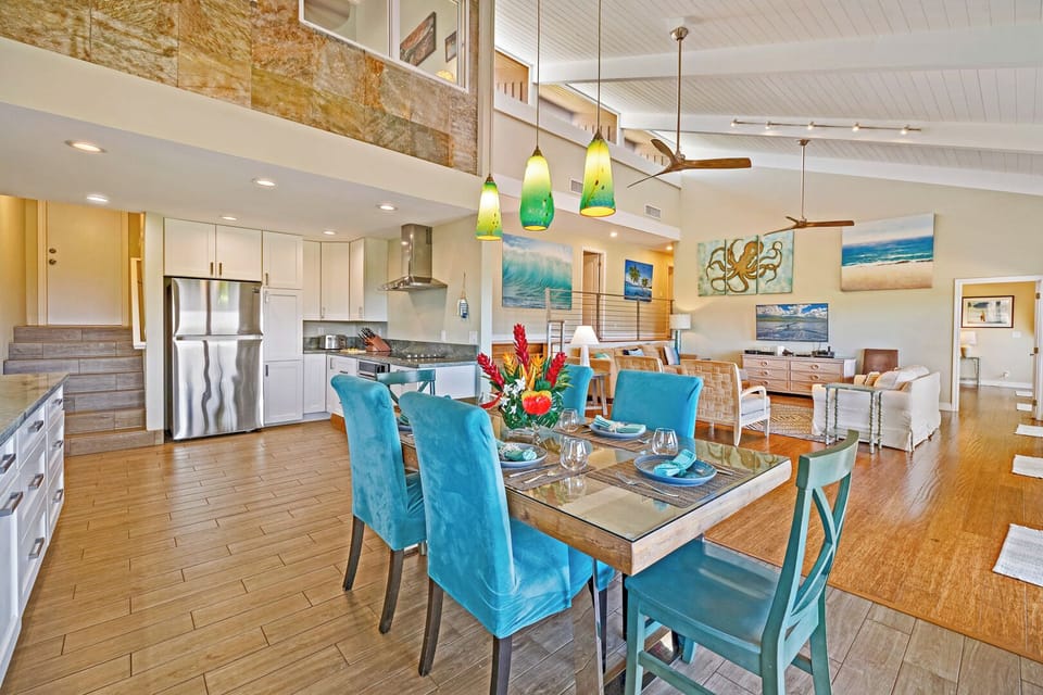This open-concept kitchen with vibrant lighting and modern amenities offers seamless access to the dining and living areas, perfect for family gatherings.
