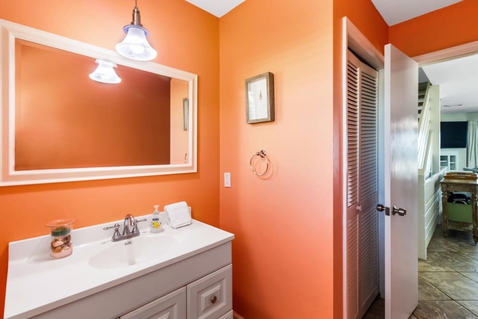 Find all the details on the main level half bath — tight but fully functional for a group coming in from the beach.