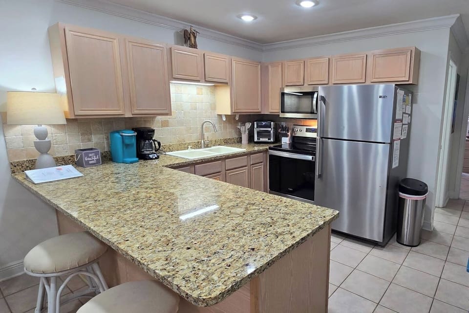 Granite countertops, full stainless appliances, and enough prep space to cook something worth sitting down for — this kitchen earns its keep.
