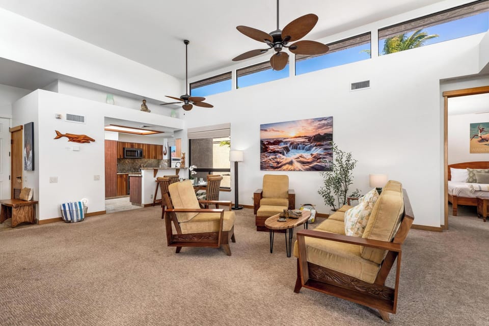 Relax in your spacious open-concept living area with stylish tropical furnishings and soaring ceilings that create an airy, welcoming atmosphere.