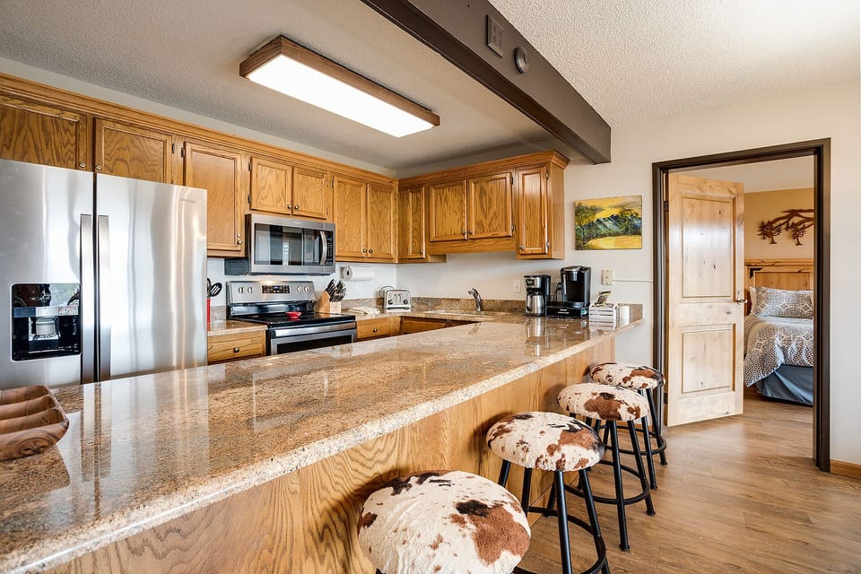 Your rustic kitchen features granite countertops, modern appliances, and cozy cowhide bar stools where you'll love gathering for morning coffee.