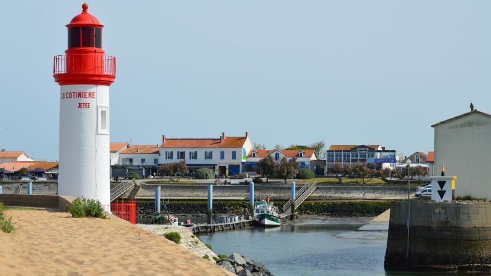 The La Cotinière jetty lighthouse marking the entrance to a fishing harbor on Île d'Oléron, France.