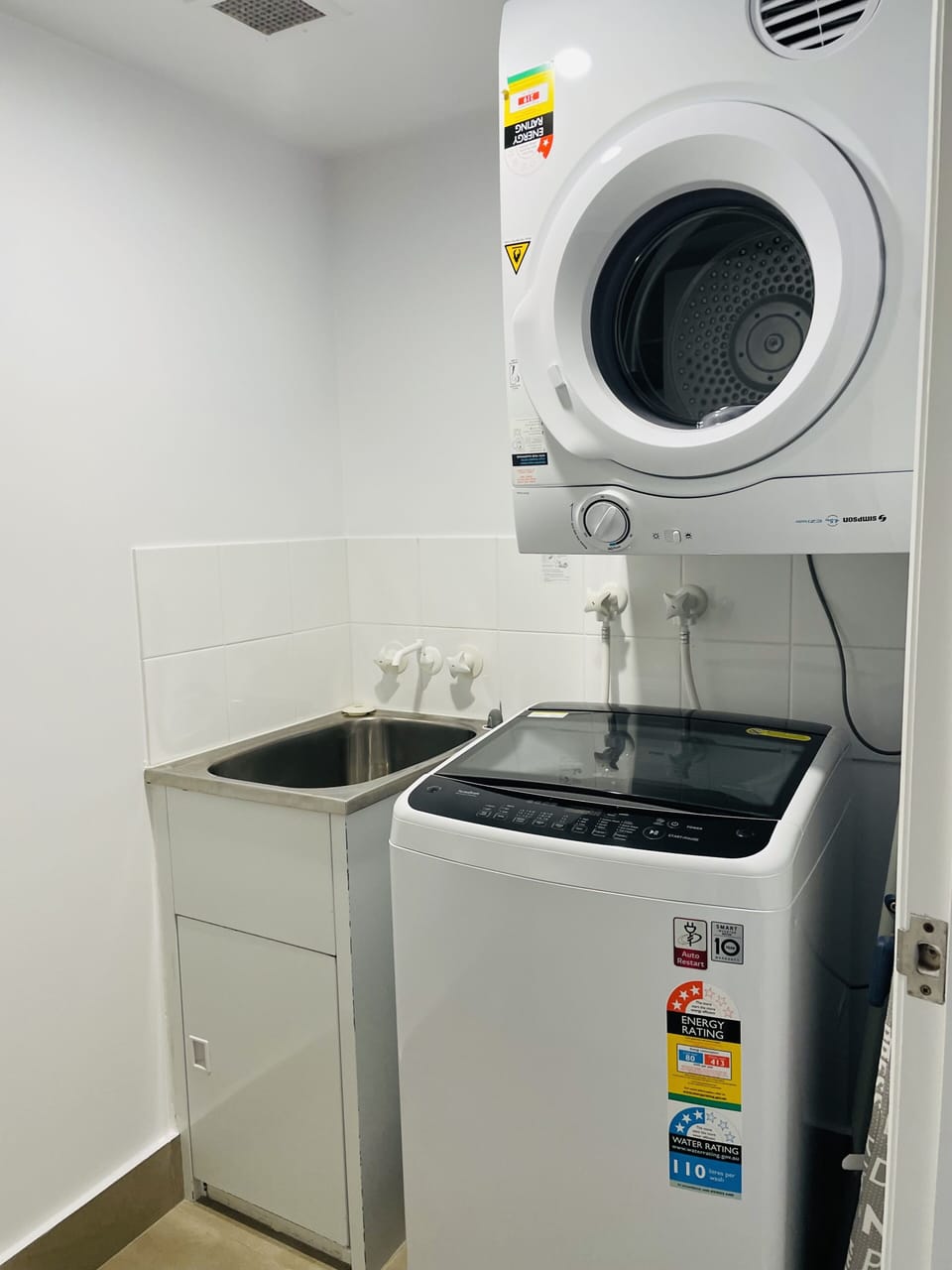 Laundry room with washing machine and tumble dryer