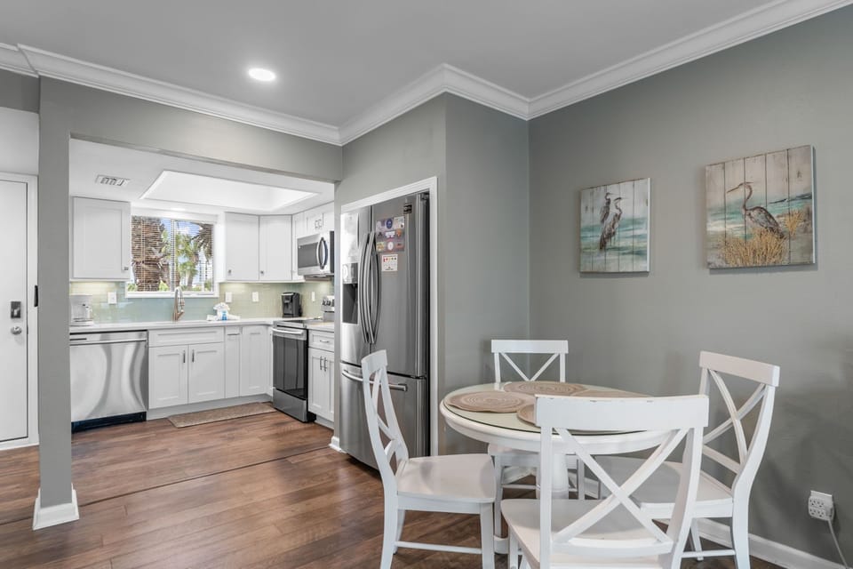 Your open-concept kitchen and dining area features coastal-inspired decor, modern appliances, and elegant hardwood floors perfect for memorable meals.