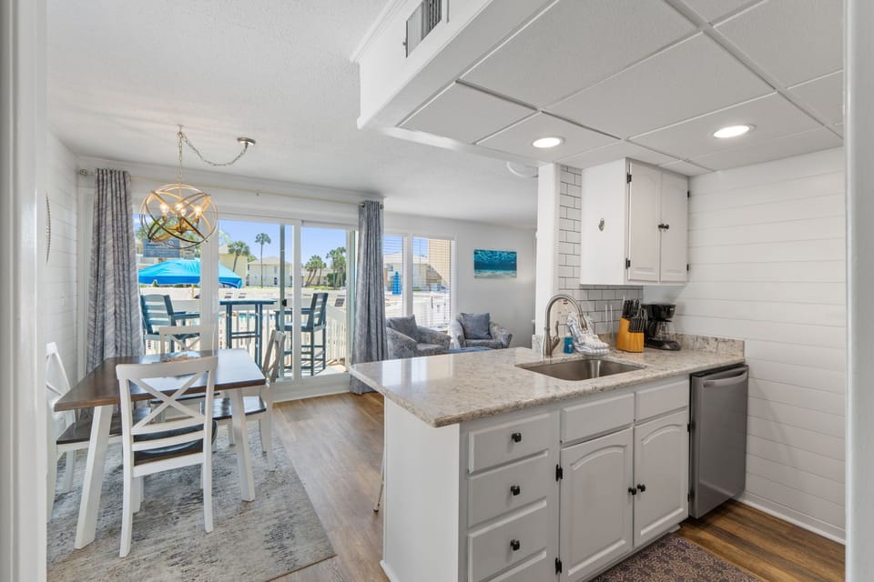Your bright, open kitchen flows seamlessly into the dining and living areas, where coastal views through sliding glass doors invite relaxation after a day at the beach.