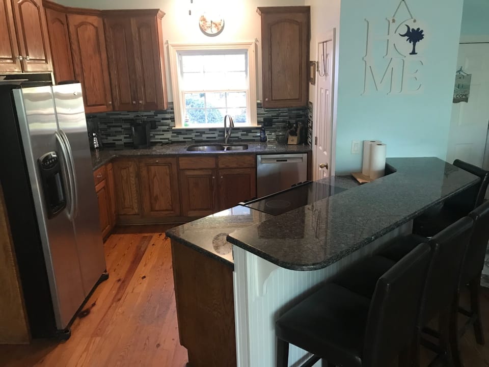 Open kitchen area where all can gather with stainless appliances. 