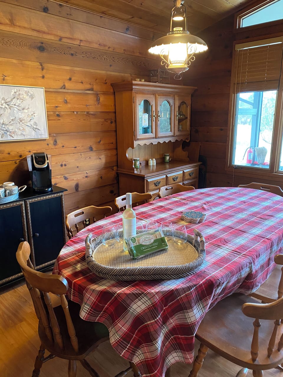 Dining area is bright. Hutch contains more dishes and accessories.