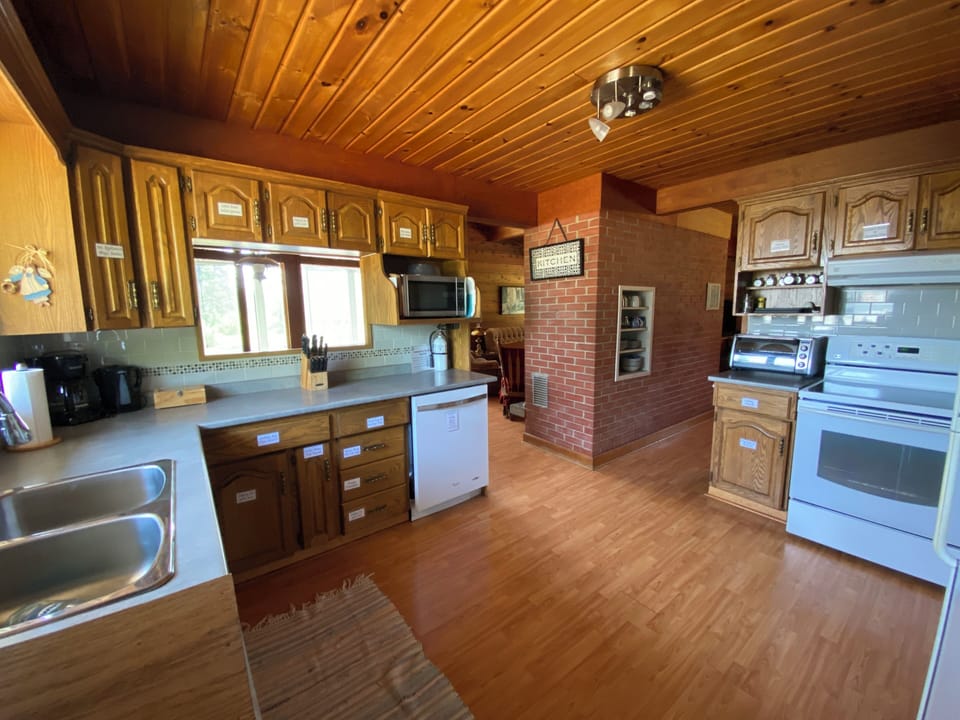 View of kitchen from front foyer. Well stocked plus empty cupboards for guests