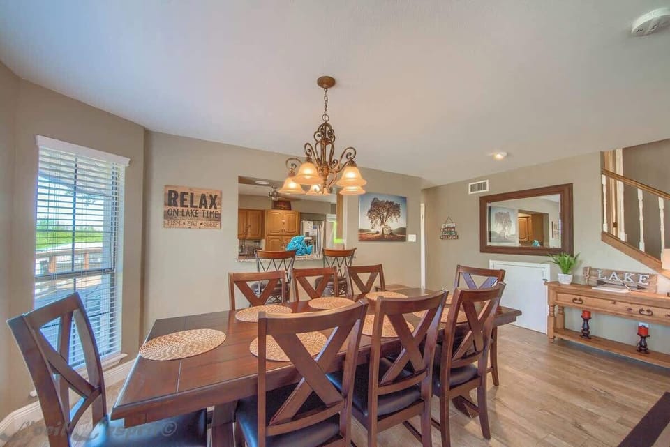 The dining area has a large table with seating for 8 and 2 bar stools at the breakfast bar. 
