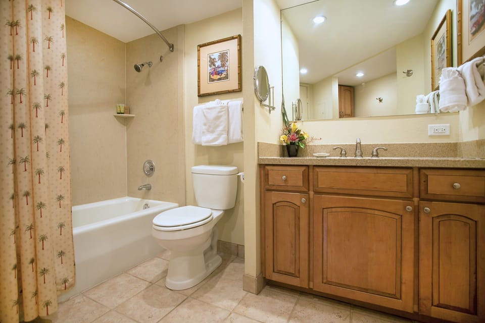 Bright, spacious bathroom with warm tones and thoughtful details to make your stay feel like home. Fresh towels, granite counters, and a relaxing tub await you after a day exploring.