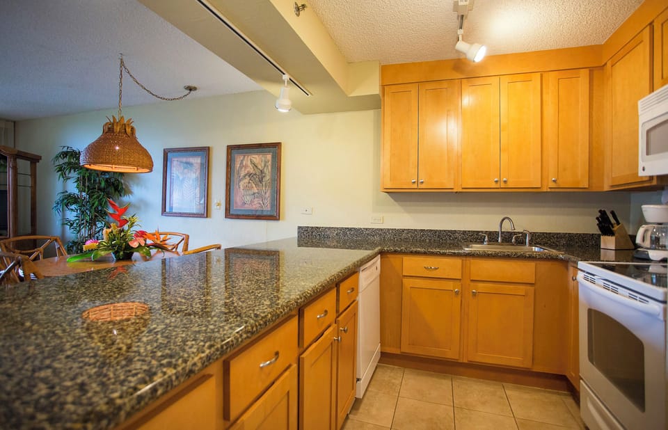 Step into your fully equipped kitchen with granite countertops, warm wood cabinetry, and everything you need to prepare delicious meals during your island stay.