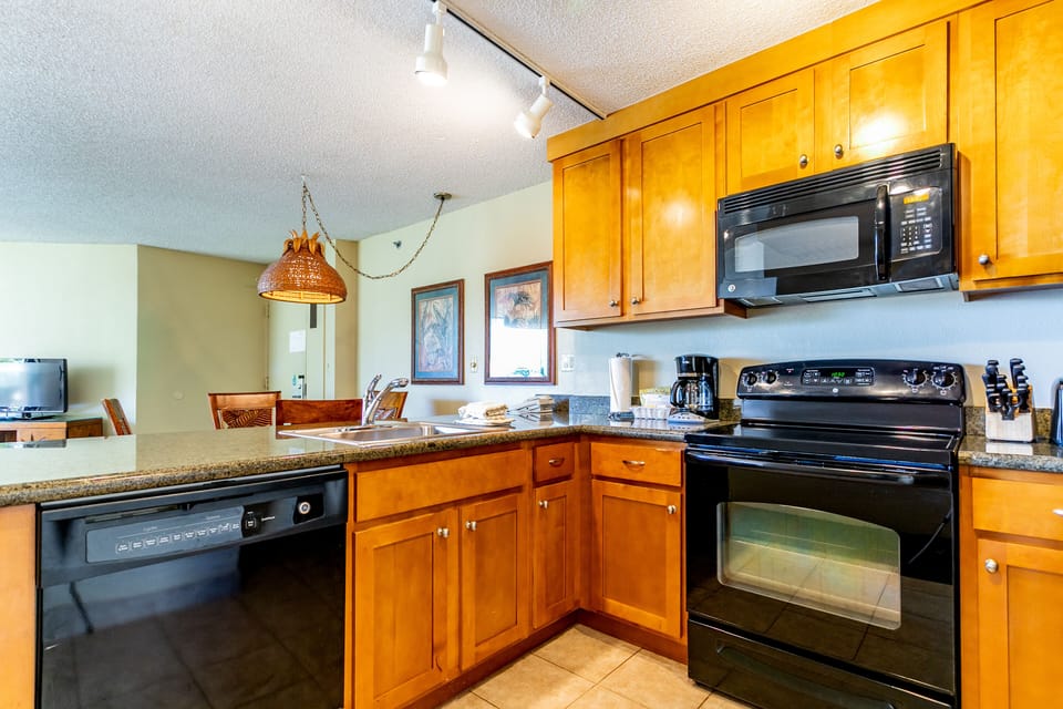 Your fully equipped kitchen features warm wood cabinetry, granite counters, and modern appliances—perfect for preparing home-cooked meals with ease and style during your stay.