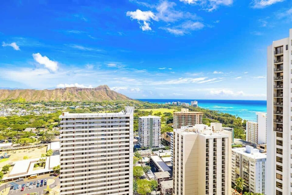 Cityscape view with ocean and mountain backdrop under a clear blue sky