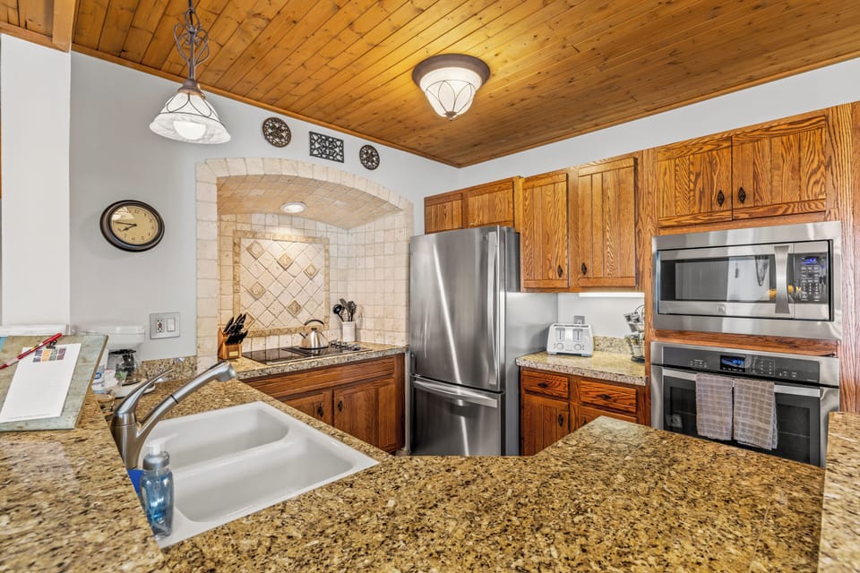 Well equipped kitchen with wood cabinets and stainless steel appliances