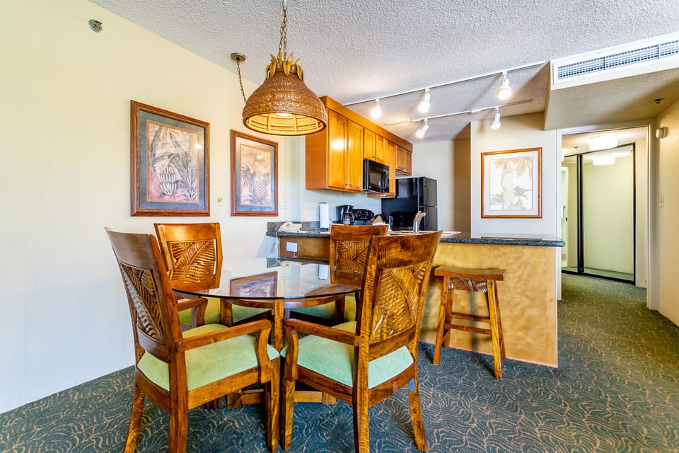Your island-inspired dining space features carved wood furnishings, a cozy breakfast bar, and a fully equipped kitchen—perfect for preparing and enjoying meals together during your stay.