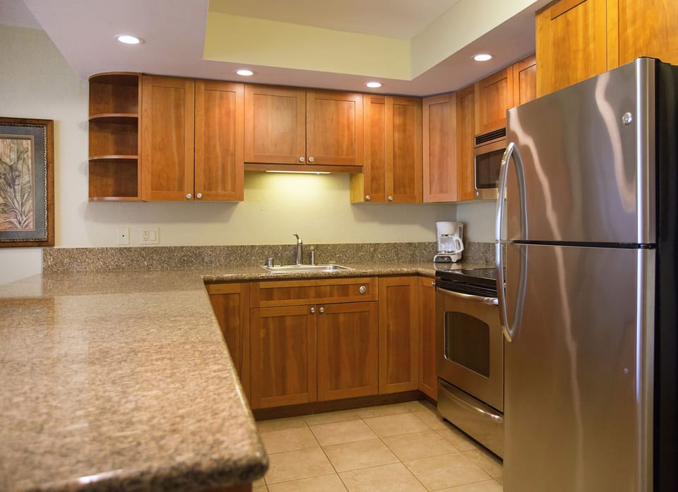 Your full kitchen features warm wood cabinetry, granite countertops, and stainless appliances—perfect for preparing everything from morning coffee to home-cooked meals during your stay.