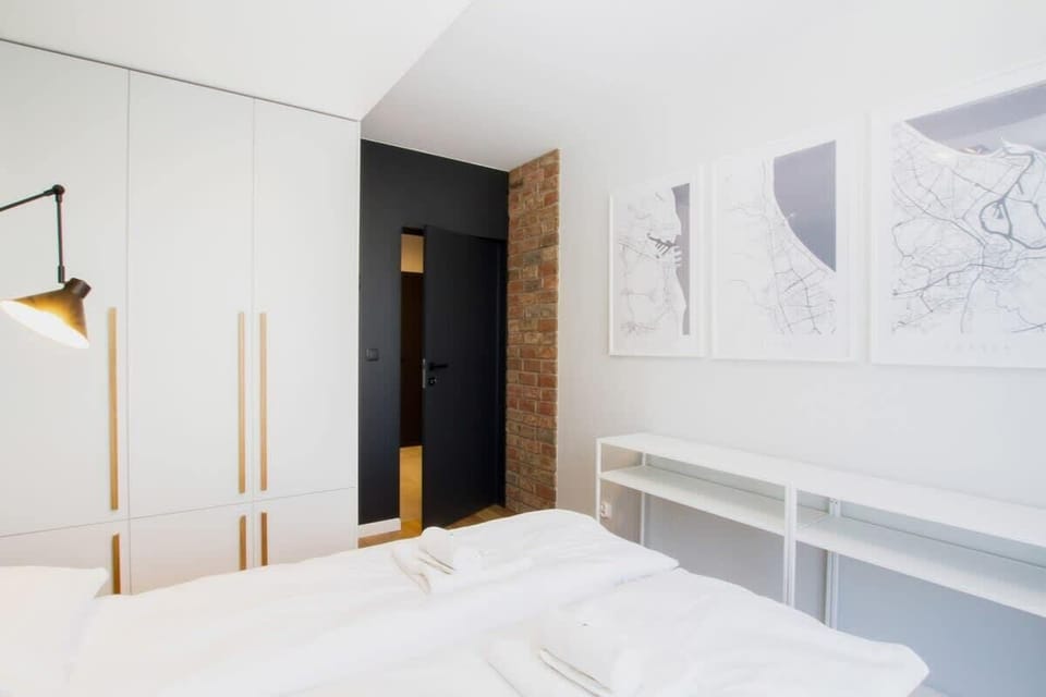 Another bedroom with a teal accent wall and pendant lighting, featuring a comfortable bed and minimalistic decor, creating a relaxing atmosphere.