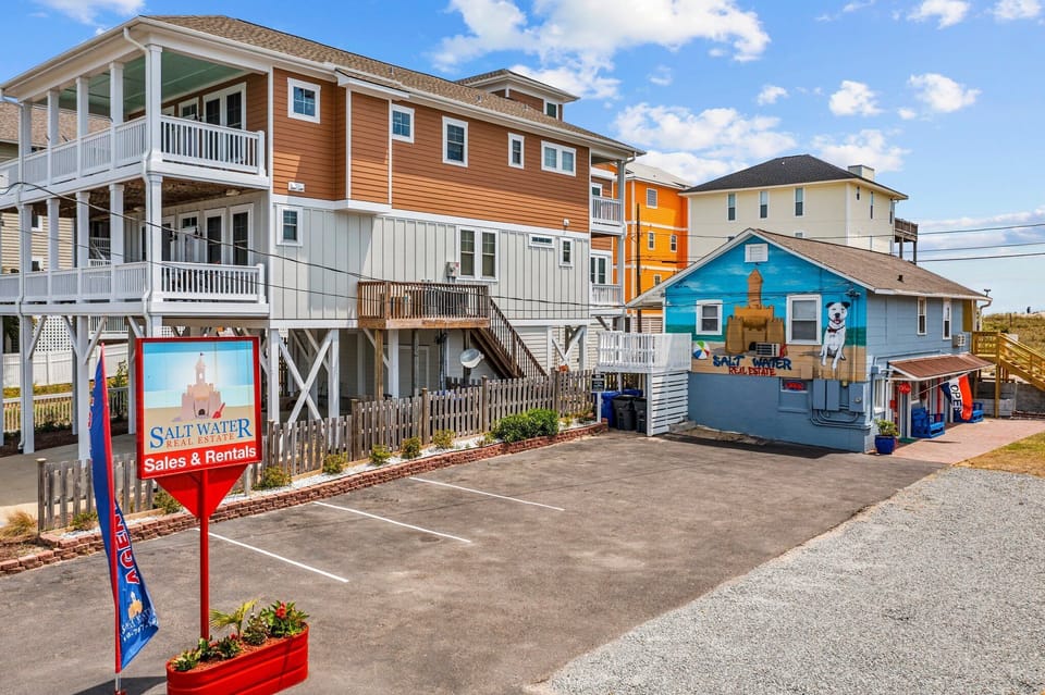 Colorful beachside rental properties showcase the vibrant coastal community atmosphere with convenient parking and local charm.