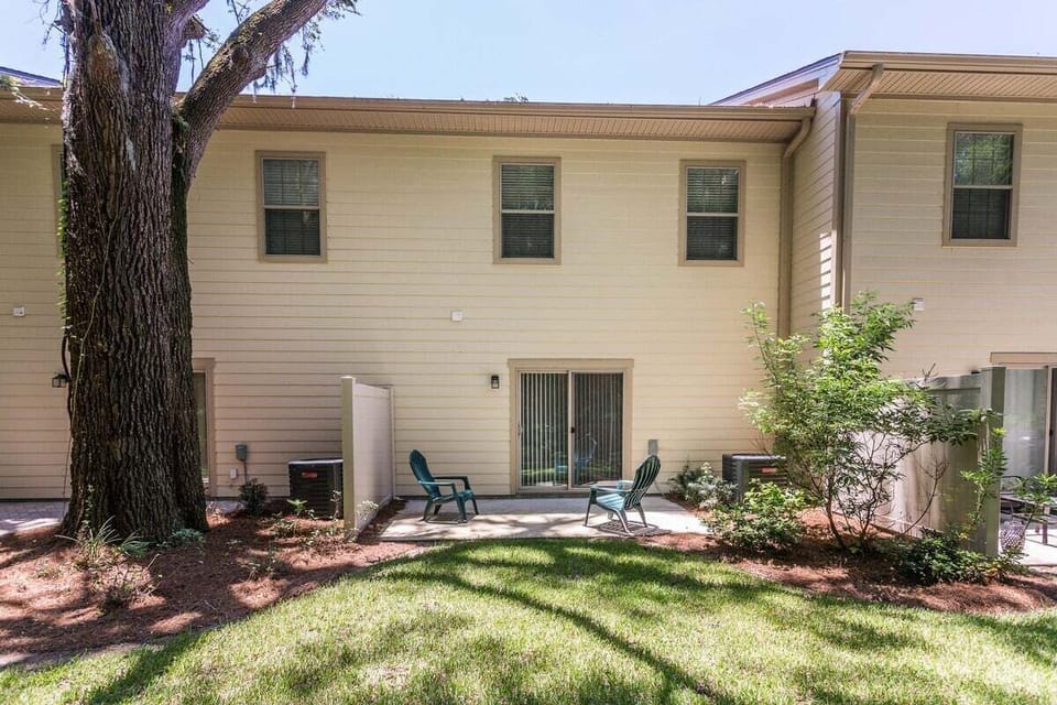 Property rear exterior with patio seating and trees