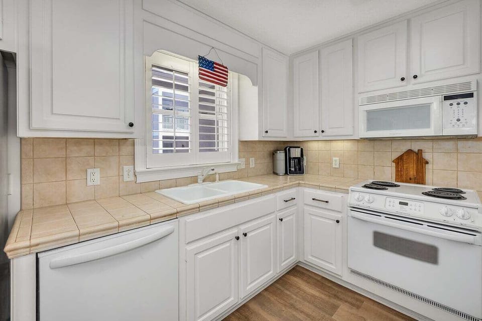 White kitchen with tile backsplash and stove