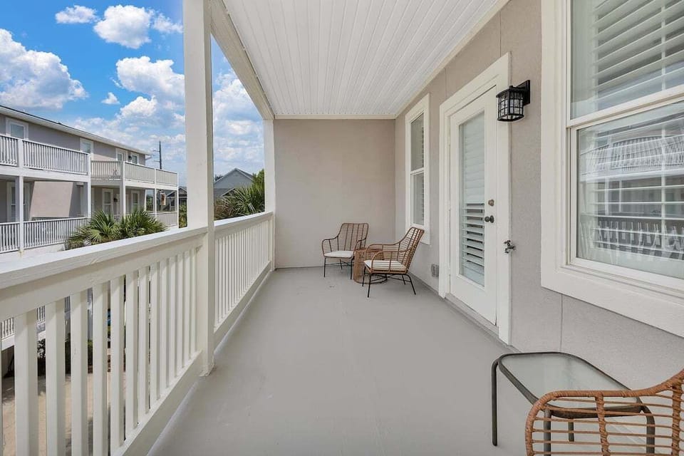 Covered balcony with rocking chairs and neighborhood view