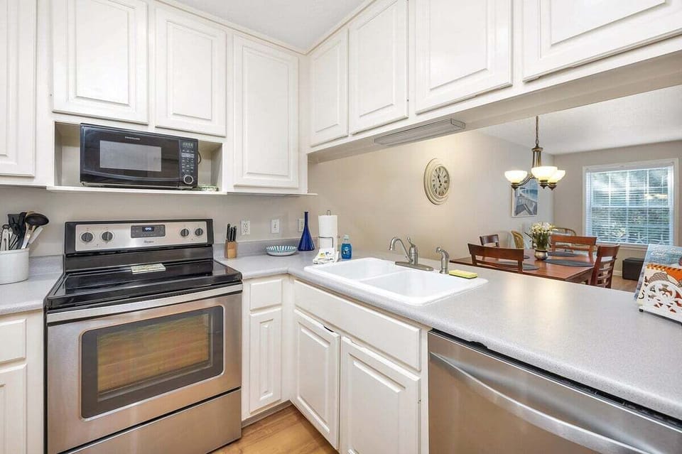 White kitchen with stainless range and view to dining area