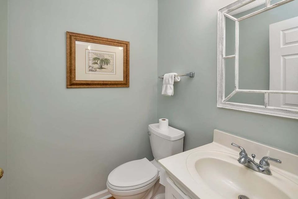 Bathroom with gray walls, vanity, and framed artwork