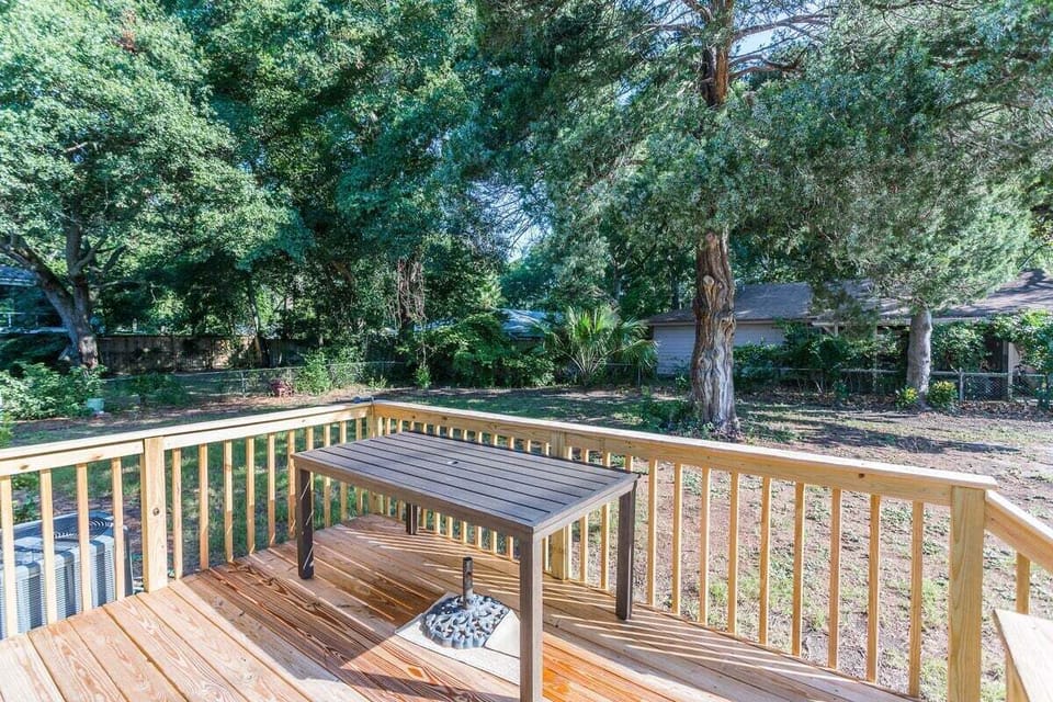 Wood deck overlooking shaded backyard with trees
