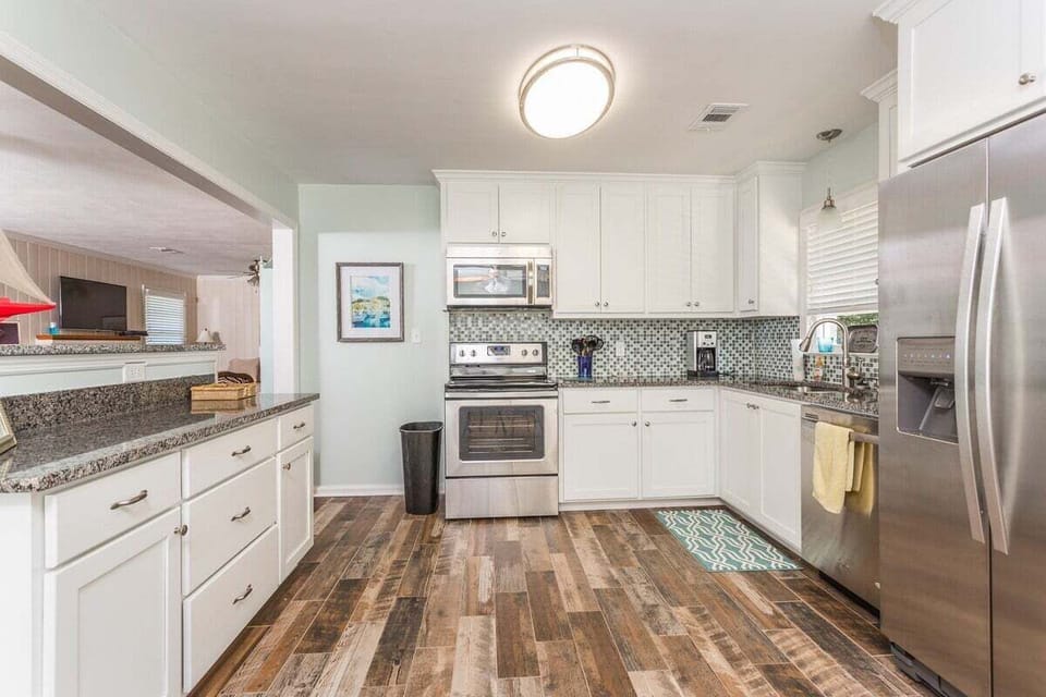 Kitchen with white cabinets, dark counters, and stainless appliances