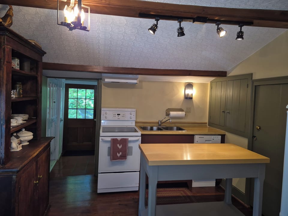 Fully equipped kitchen with pots and pans, and dishes to prepare a meal.