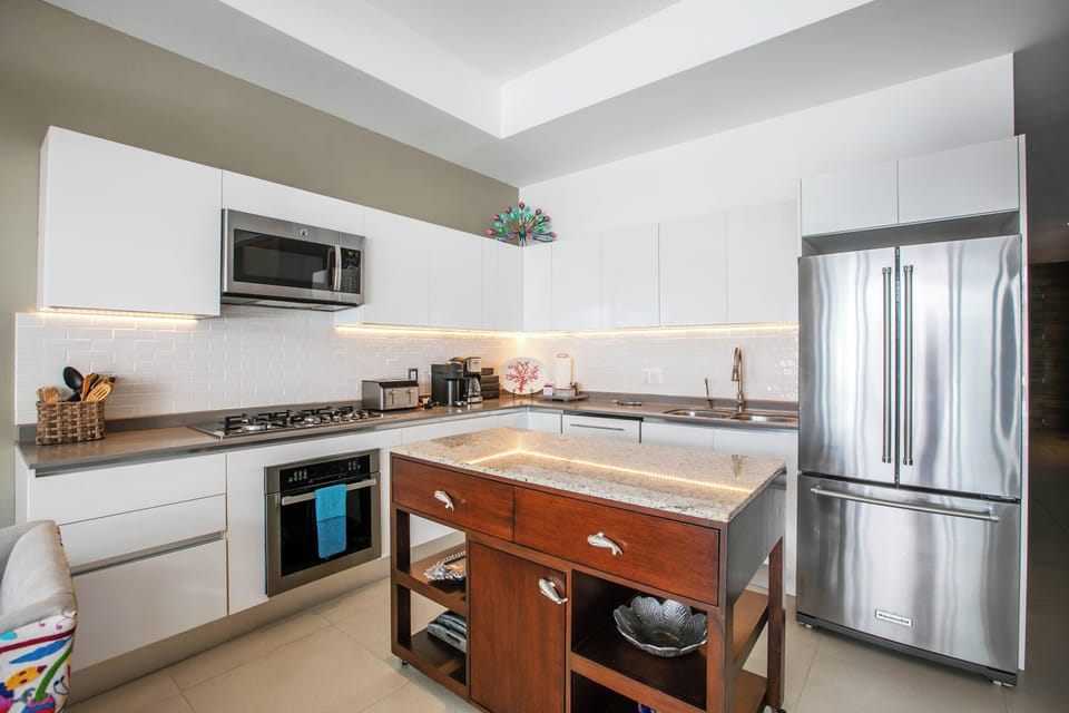 Your fully equipped kitchen features sleek stainless appliances, gas cooking, and a stylish island with granite countertops—perfect for preparing fresh meals during your stay.