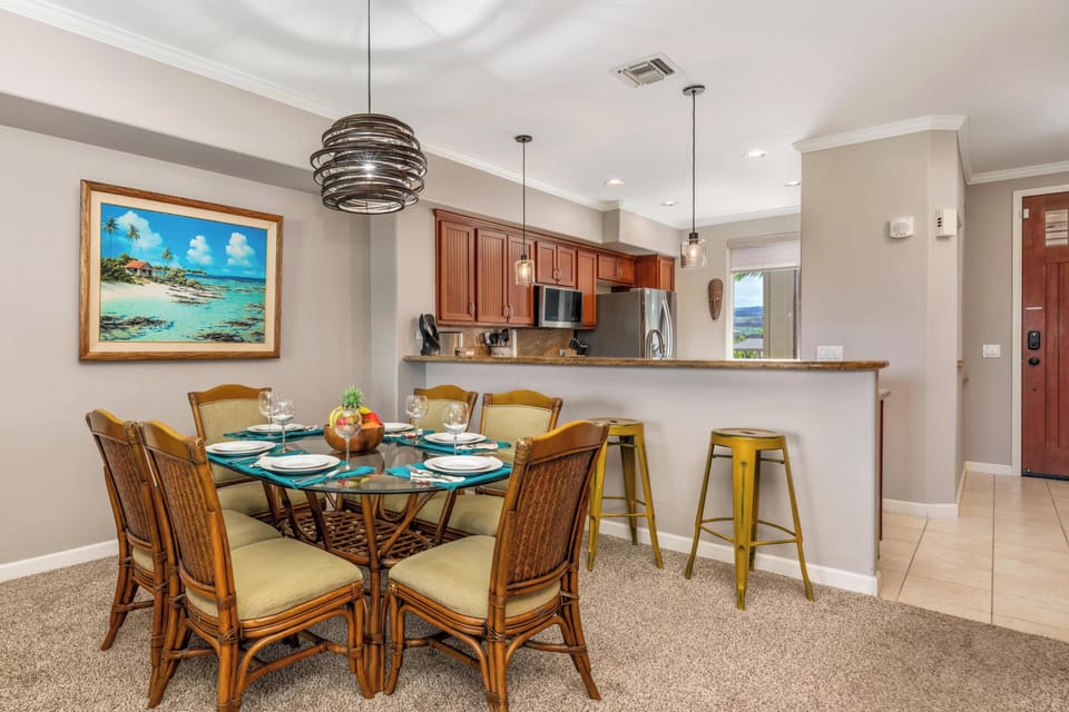 Your open-concept dining and kitchen space blends tropical charm with modern comfort, featuring a beautifully set table ready for memorable meals.