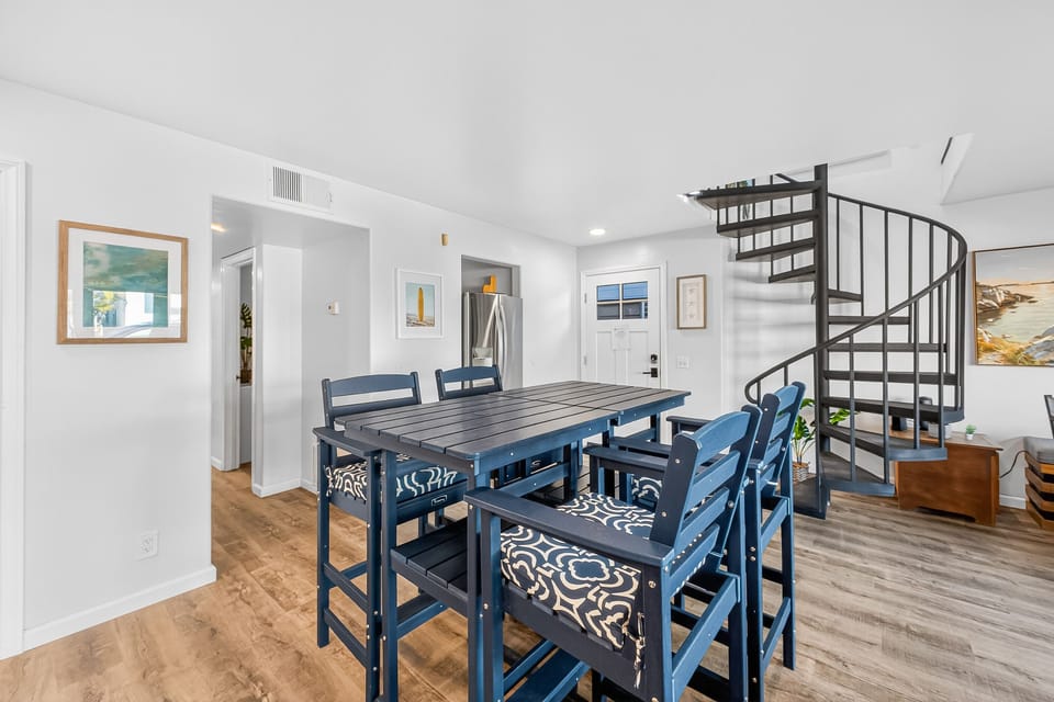 Bright open floor plan with kitchen, breakfast bar, dining, and living area—perfect for gathering, family meals, and relaxing after a day at the beach. Spacious and inviting for groups.