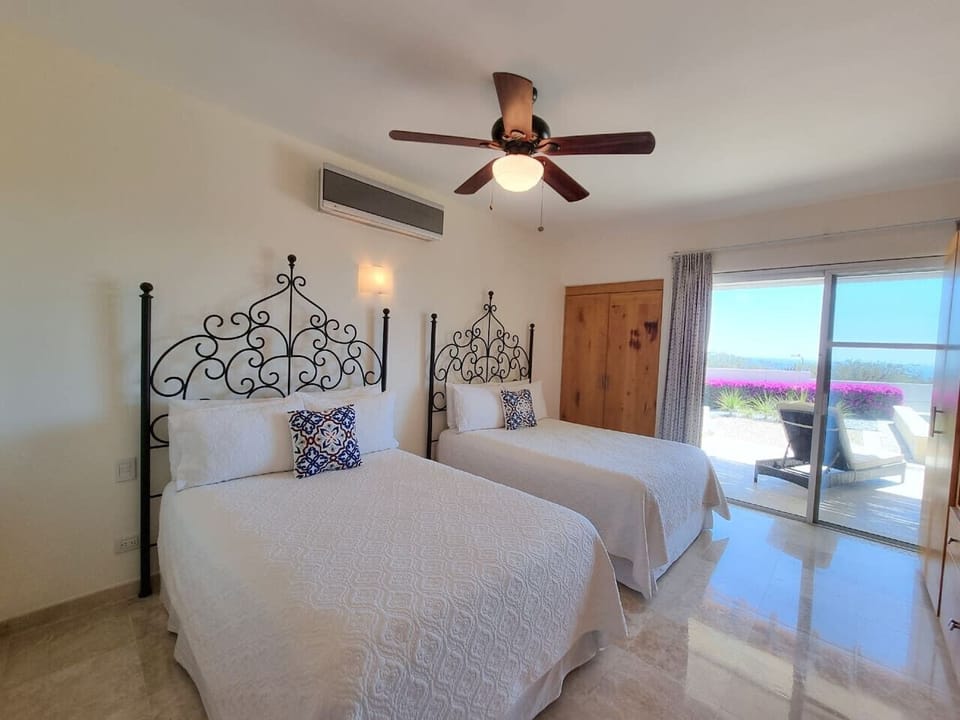 Bright bedroom with queen beds and direct access to the outdoors.