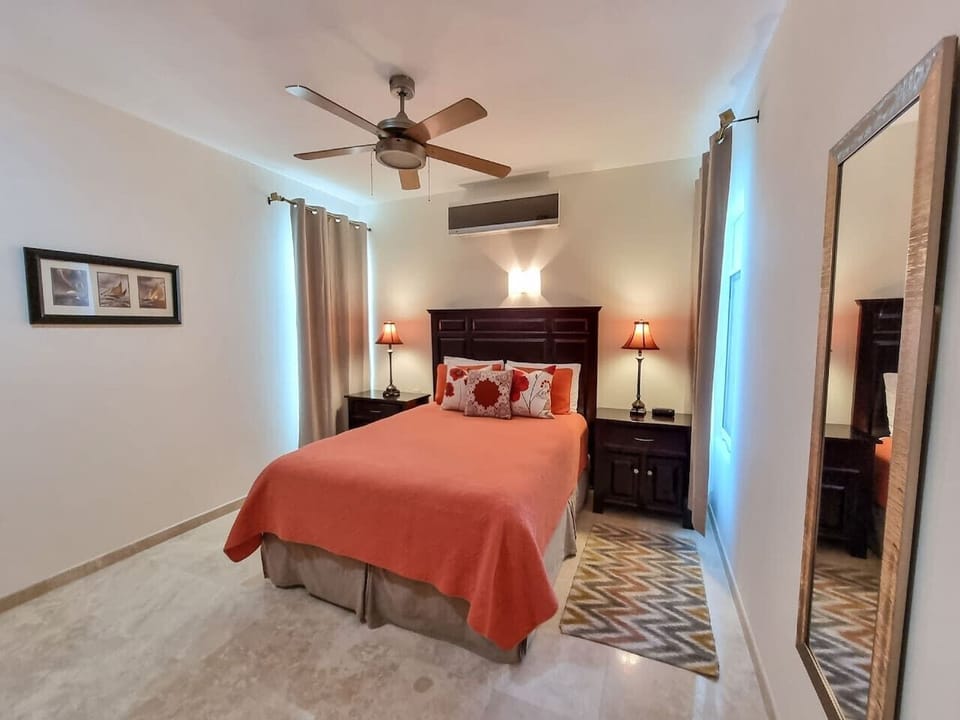 A cozy bedroom with a warm color palette and ceiling fan for comfort.