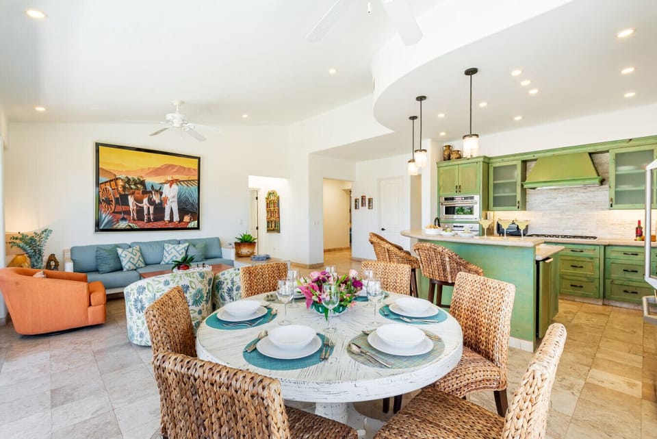 Coastal Living Lounge: Relax after a day of exploring in a air-conditioned living space complete with a plush couch, vibrant accent chairs, authentic artwork, and expansive glass sliding doors that flood the entire open-concept room with natural sunlight.