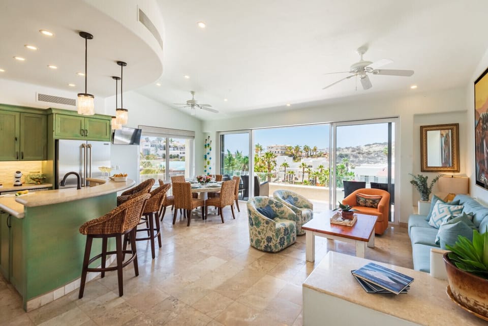 Open Kitchen & Dining Bar: Chat with the chef while enjoying appetizers and drinks at the raised island breakfast bar, featuring woven bar seating, modern pendant lamps, and easy access to the main living areas.