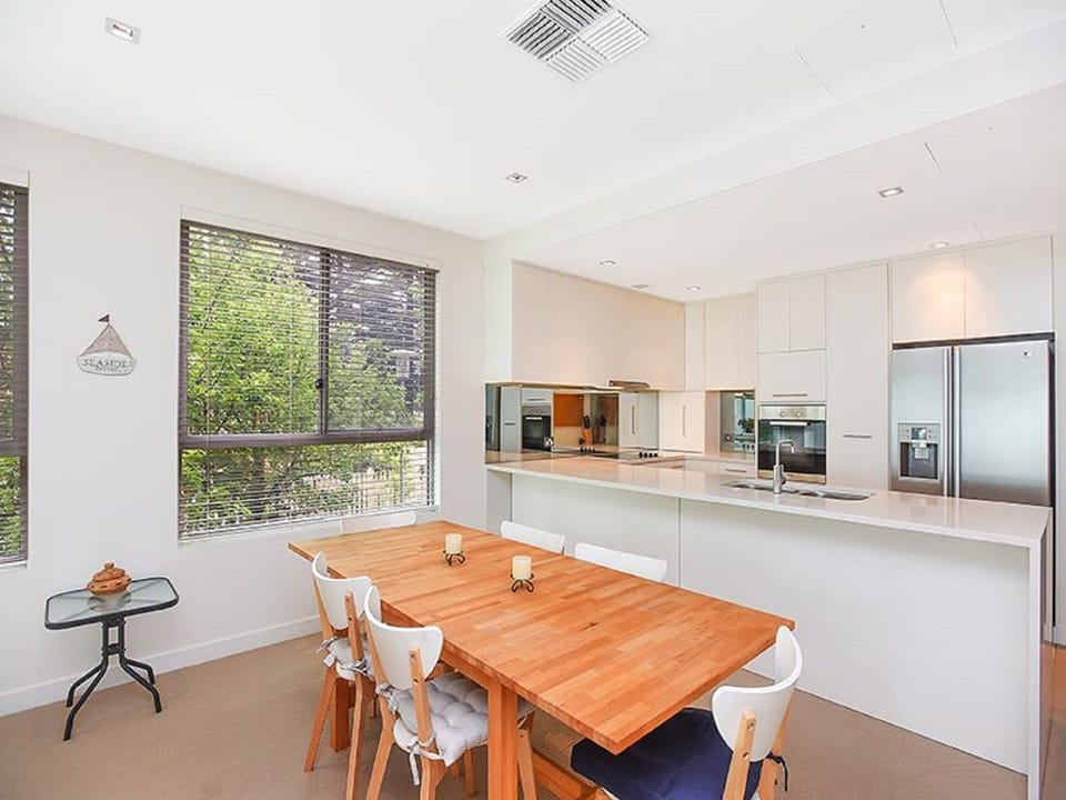 Fully equipped kitchen with modern appliances including stovetop, oven, microwave, full-sized fridge, kettle, toaster, and dishwasher.