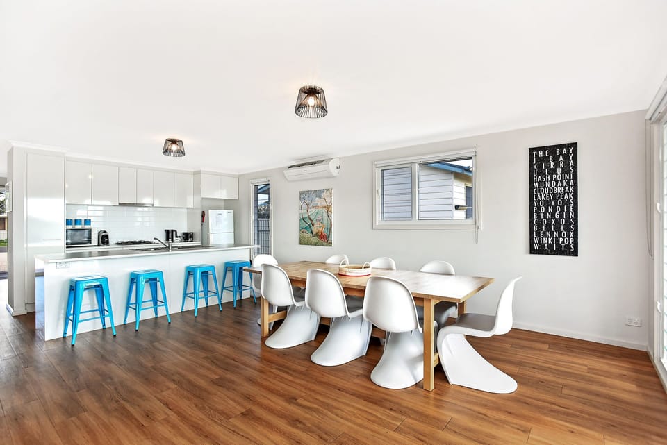 Large open kitchen, dining, and living area with seamless indoor-outdoor flow to the covered deck enhances the holiday lifestyle.