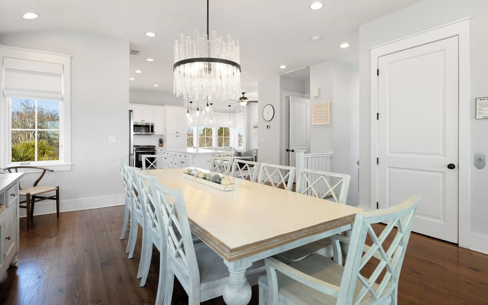 Gather around your elegant dining table for memorable meals beneath a stunning chandelier in this bright, open space.