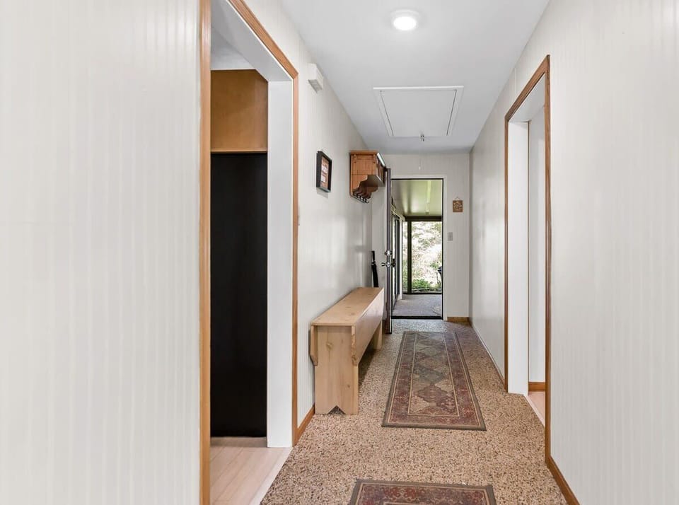 Main entrance hallway of White Oaks Haven leads straight ahead to the 3-season sun porch, left into the kitchen & laundry area, or right to the 3 queen bedrooms & 1 bathroom