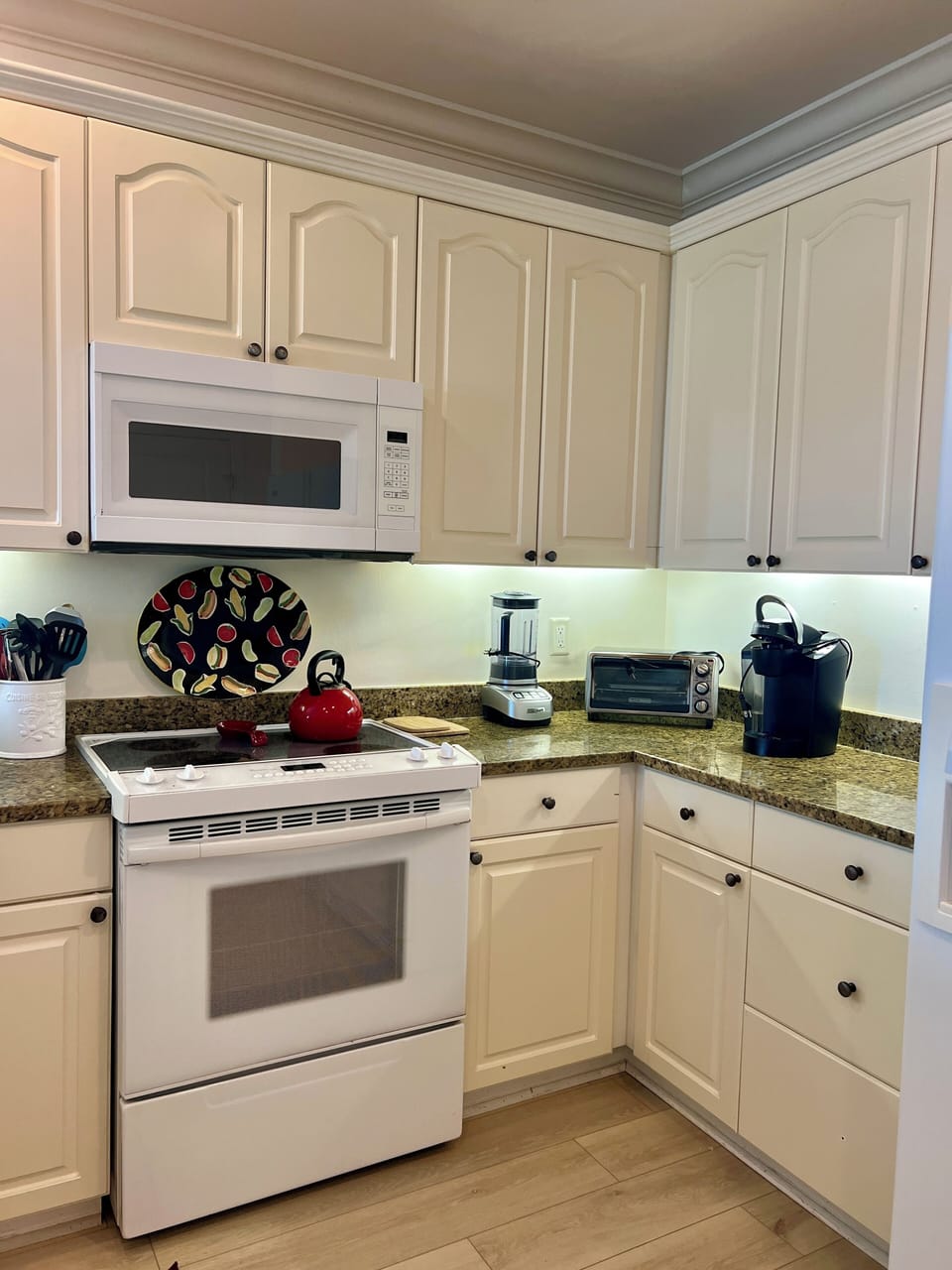 Kitchen with electric stove and two types of coffee makers.