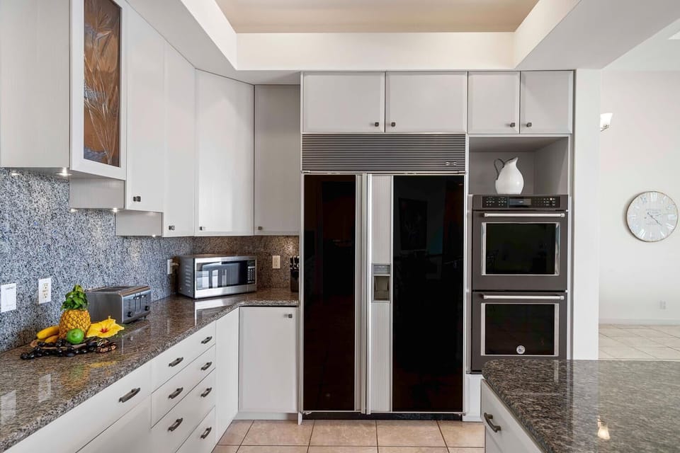 Kitchen with built-in refrigerator, double oven, and granite countertops.