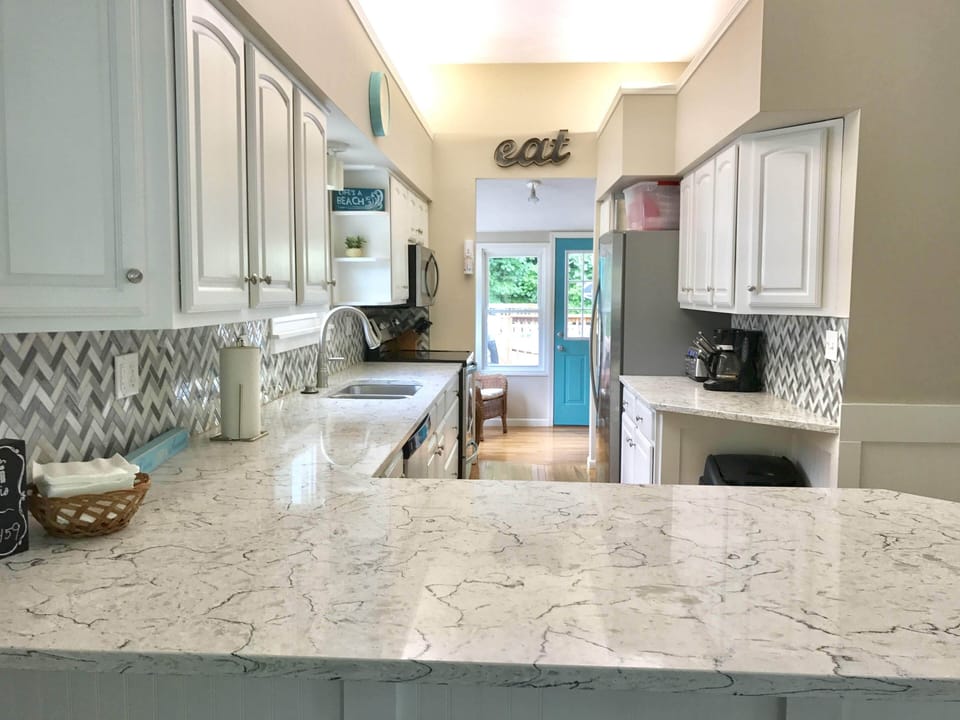Kitchen leads to the sunroom with overlooks the heated pool in the backyard.